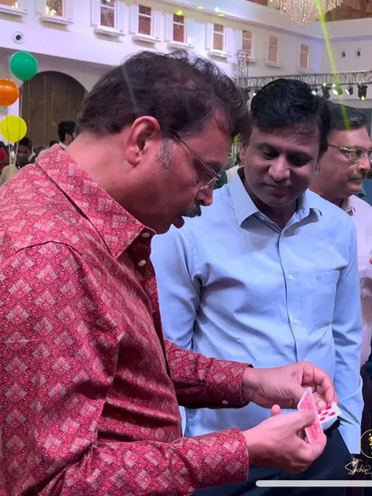 A spectator examines the cards, finding nothing out of the ordinary, just before the magic happens. This involvement is key to close-up illusions.