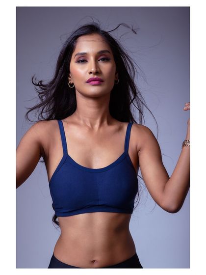 A colorful, moody portrait with a focus on the model's direct gaze. The lighting creates a dramatic effect, making the image feel intense and captivating.