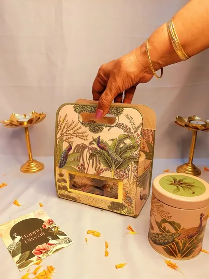 Our peacock theme is a festive favorite. This hamper, housed in a beautiful printed box, includes three matching tins filled with dry fruits, chocolates, and cookies.