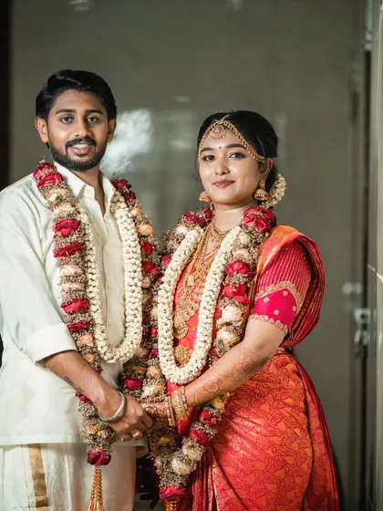 A happy couple posing for a photo on their wedding day. The bride's makeup is radiant and her smile is infectious.