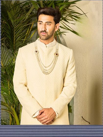 Another look at the off-white sherwani, demonstrating its flawless fit and elegant drape. This piece is crafted to make you feel confident and poised on your wedding day.