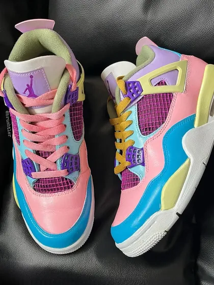 A top-down view of the custom pastel Jordan 4s, showing the mismatched laces.