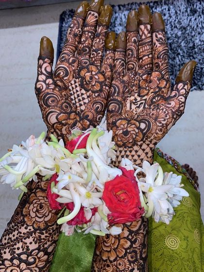 More views of Fathima's bridal henna, showing the personalized name and the stunning floral jewelry that completes the look.