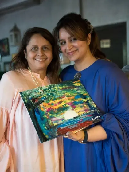 A participant and I with her vibrant, abstract masterpiece. I love helping my students explore colors and textures to create something that is uniquely theirs.