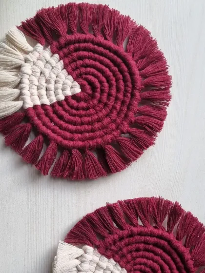 A top-down view of the magenta and white coasters, showing the clean spiral and neatly combed fringe.