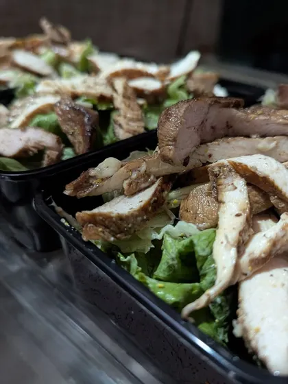 A behind-the-scenes look at our meal prep process for the Grilled Chicken Caesar Salad. We prepare meals in batches to ensure consistency and freshness, making it easy for you to hit your daily protein goals.