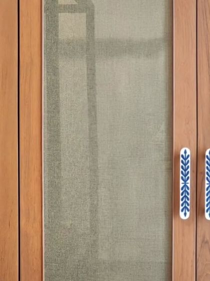 Custom door handles with a hand-painted blue and white ceramic inlay. These small, bespoke elements are an opportunity to infuse personality and craftsmanship into a project, making everyday interactions with the furniture more meaningful.