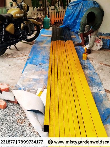 The preparation stage is vital. Here, metal beams are being coated with a protective primer before fabrication begins for a 10mm toughened glass pergola project in Sarjapur.