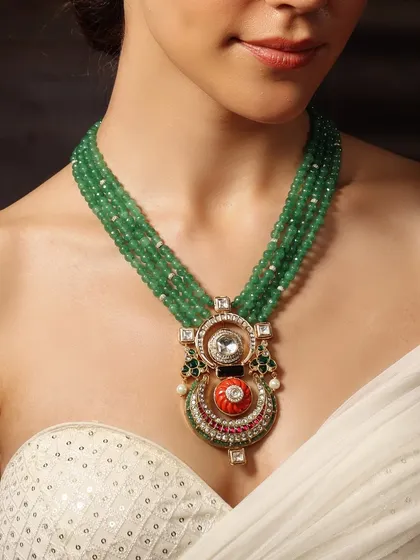 A modern take on tradition. This Emrosia piece combines a multi-strand emerald bead necklace with a unique polki and coral pendant.