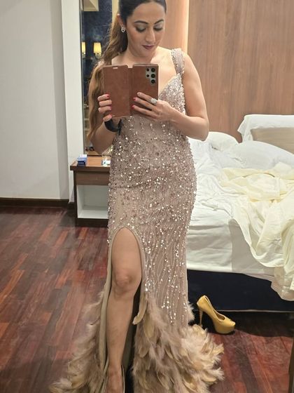 A quick mirror selfie before heading out to host. This sequined gown with a thigh-high slit and feathered trail was all about bringing the glam factor to a wedding reception.