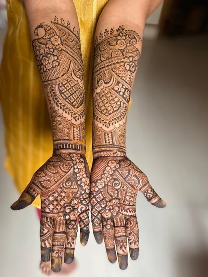 A beautiful bridal design featuring peacocks, a symbol of grace and beauty, on the back of the arms.