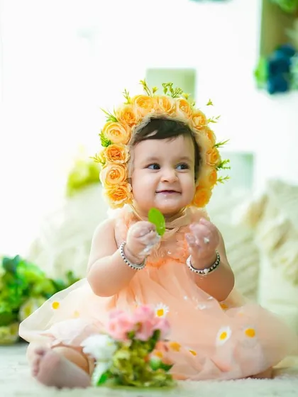 A happy baby girl in a beautiful floral bonnet after her cake smash. This is a sweet and simple way to get some clean portraits after the messy fun.