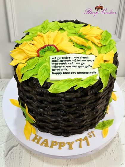 A beautiful flower basket cake for a 71st birthday. The basket is woven from chocolate frosting and filled with handcrafted fondant sunflowers, along with a heartfelt message for a beloved mother.