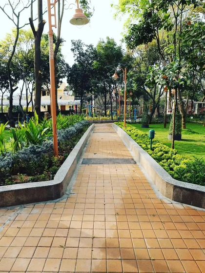 A clear view down a paved path in a community park. The surrounding lawns and garden beds are all under my care, keeping the space clean, healthy, and usable for the public.