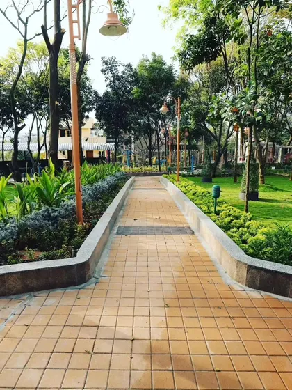 A clear view down a paved path in a community park. The surrounding lawns and garden beds are all under my care, keeping the space clean, healthy, and usable for the public.