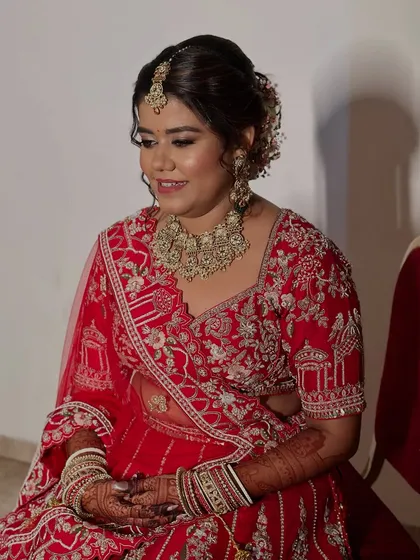 Poised and ready for her big day. The soft glam makeup ensures she looks elegant and not overdone, even with the heavy traditional attire.