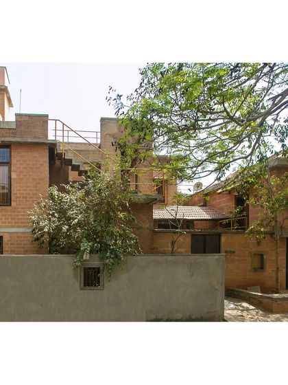 The exterior of the Professor's Residence in Bengaluru, a project that became a laboratory for our ecological ideas. The design features multiple levels and courtyards, with all living spaces oriented towards a neighboring orchard for privacy and views.