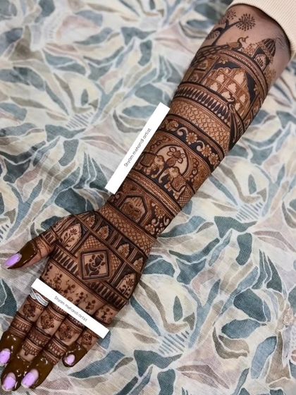 A full-arm bridal design featuring bands of elephants, peacocks, and geometric patterns, showcasing a classic and timeless style.