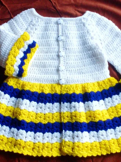 A bright and cheerful baby frock with bold blue, yellow, and white stripes. This handmade cardigan is perfect for adding a splash of color to any outfit.