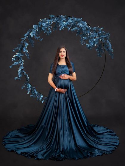 This teal gown is perfectly complemented by a matching floral hoop, creating a cohesive and artistic maternity portrait.
