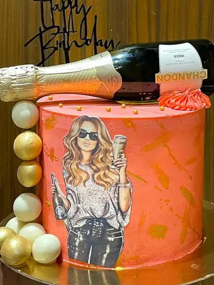 Celebrate in style with this Chandon champagne bottle cake. The bottle itself is a realistic, edible sculpture lying atop a chic, modern cake, perfect for milestone birthdays.