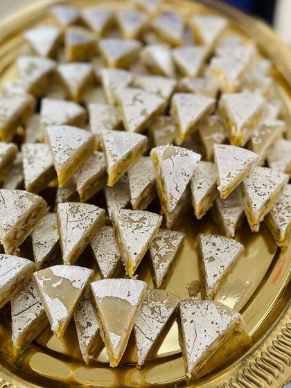 A platter of my signature Dryfruit Sandwich sweets. The layers of nuts and mawa, dusted with powdered sugar, make it a visually stunning and delicious dessert.