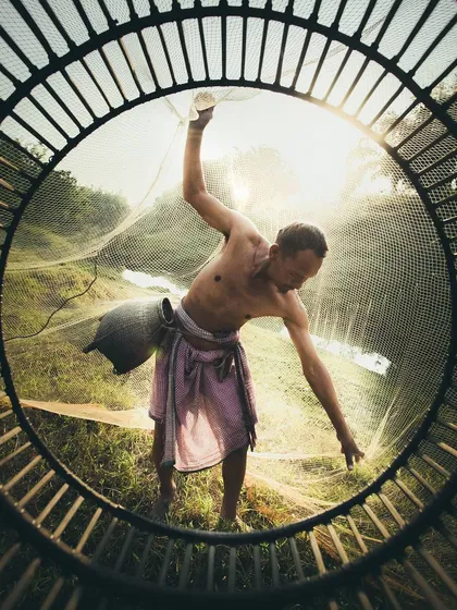 A beautifully composed shot of a fisherman casting his net, framed perfectly with dramatic backlighting. This image shows the storytelling power of the portrait and lifestyle photographers I work with.