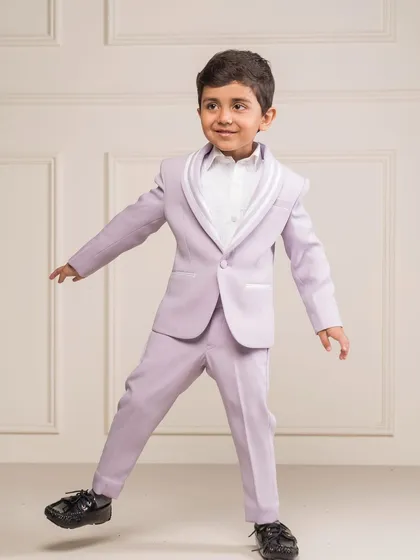 A playful shot of the lilac tuxedo, showing how the custom tailoring allows for comfort and movement. The bright color makes it a fun choice for a designer birthday suit.