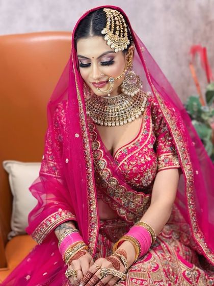 A candid, happy moment. The bride is glowing in her vibrant pink attire.