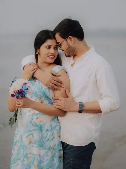 A close, loving embrace with a beautiful bouquet. This portrait of Jayashree and Anand highlights their gentle affection during their seaside photoshoot.