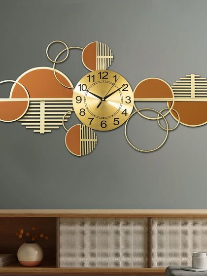 Time meets art in this handcrafted metal wall art clock. The horizontal design with abstract circles in gold and terracotta tones makes it a striking statement piece to hang above a console or sofa.