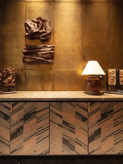 A console with marquetry shutters at the entrance of our Kolkata project. The intricate woodwork is paired with antique brass panels and contemporary art, setting a tone of crafted luxury.