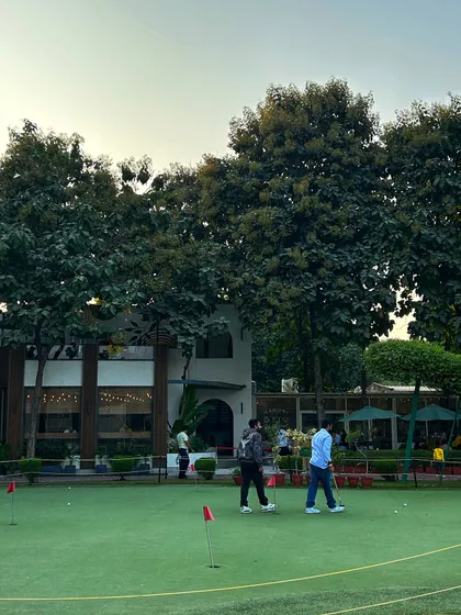 A group of golfers walks across the putting green, enjoying the beautiful surroundings.
