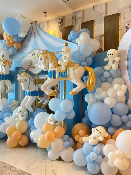 To welcome a baby boy, we designed a beautiful carousel-themed setup with pastel blue and peach balloons, classic carousel horses, and adorable teddy bears.
