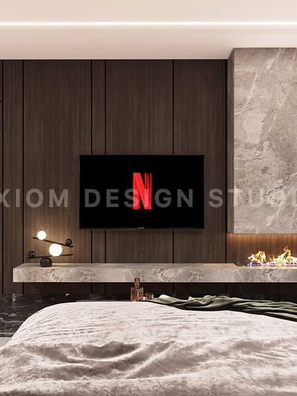 The TV wall in the same bedroom features a floating console with an integrated fireplace, set against a backdrop of dark wood paneling and marble.