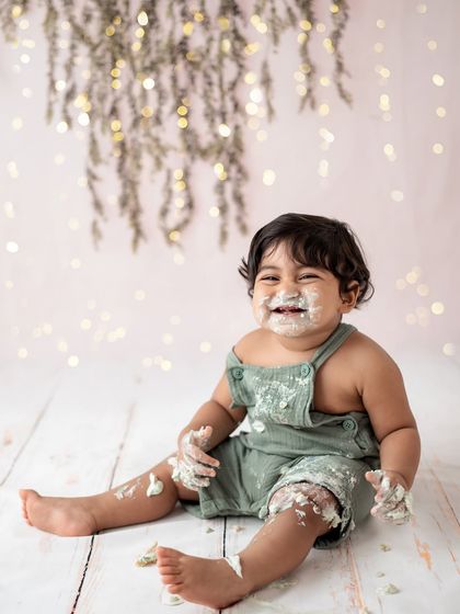 The aftermath of a successful cake smash! This little guy is covered in frosting and couldn't be happier. These are the fun moments we love to capture.