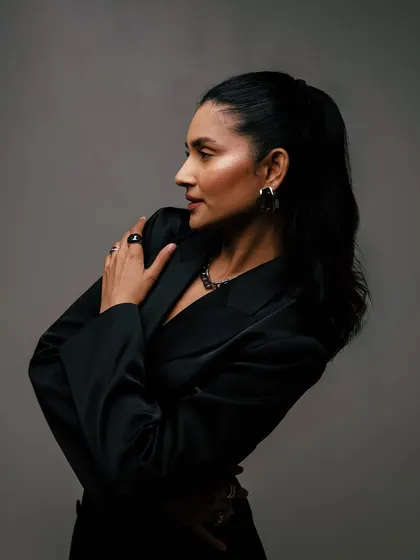 A dramatic, side-profile pose in a black blazer. This look is powerful and sophisticated.