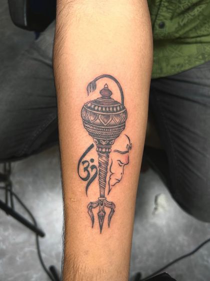 A tribute to Lord Hanuman, featuring his mace (gada), the Om symbol, and a subtle outline of his face. This design represents strength, devotion, and divine power.