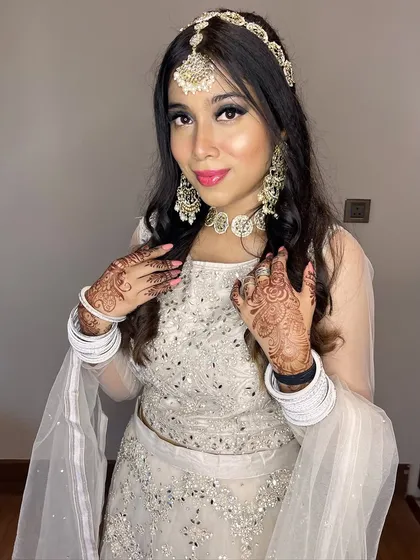 The full look, including the intricate mehndi and white bangles, which contrast beautifully with the glamorous makeup.