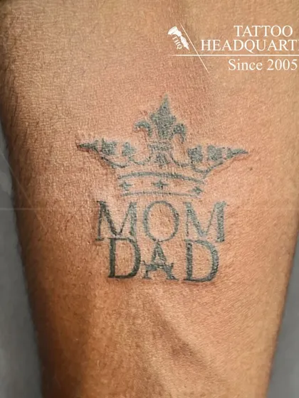 A "Mom Dad" tattoo with a crown on top, symbolizing that parents are the king and queen of the heart.