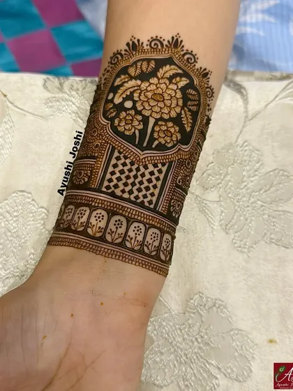 A close-up of an Indian floral armband, featuring a bold flower motif set against a checkered pattern.