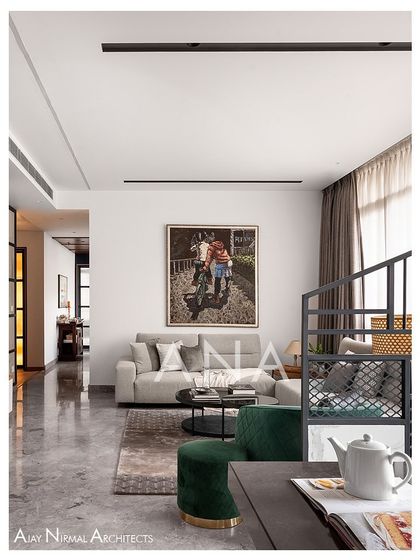 A perspective of the living room in Apartment 704, focusing on the seating arrangement. The clean lines of the sofa and the pop of color from the green chair create a simple yet elegant composition.