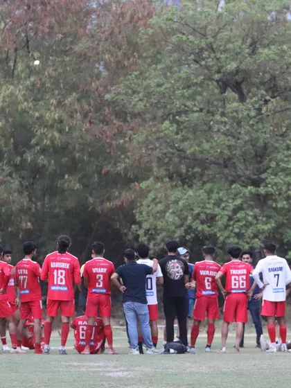 The team listens to the coach during a break in play. Tactical guidance and team cohesion are key elements of our success.