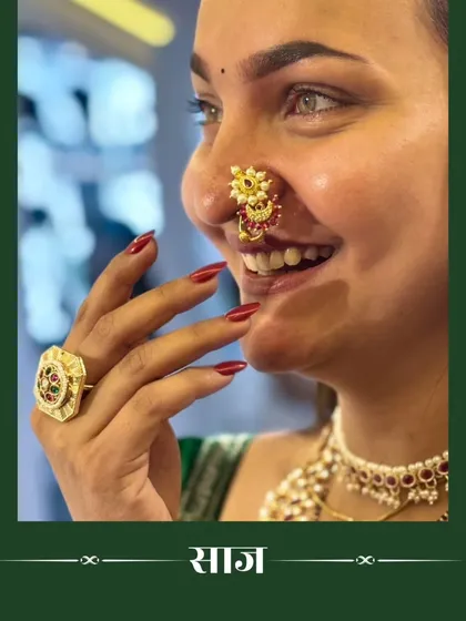 A candid shot of a model smiling, showing off a traditional nath and ring.