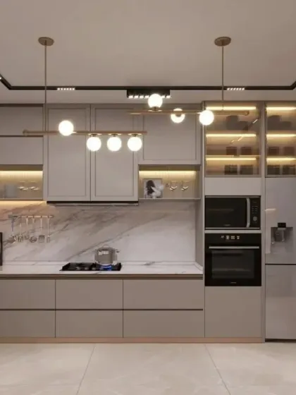 This spacious L-shaped kitchen features handleless light grey cabinetry and a smart refrigerator for a tech-integrated, modern look. We used track lighting and globe pendants to illuminate the space, while glass-front cabinets provide stylish storage.