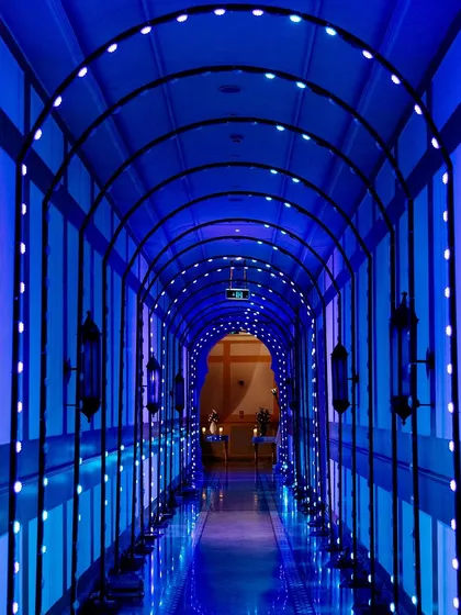 An immersive entrance tunnel for a techno-themed Sangeet, lined with blue LED lights that create a futuristic and high-impact welcome for guests.