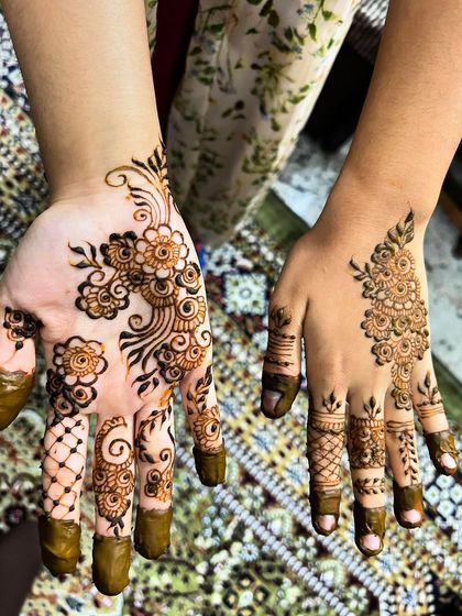 A simple and elegant Arabic henna design. One hand features a flowing floral vine, while the other has a delicate pattern on the back, perfect for a minimalist look.