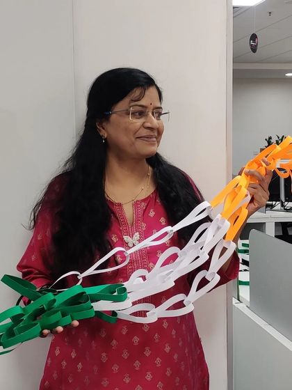 Holding up the chains of paper hearts in saffron, white, and green before they were assembled into our Independence Day flag.