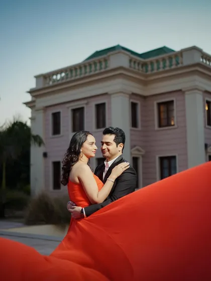 Capturing the couple's interaction against the backdrop of a beautiful building, this shot feels like a scene from a movie.