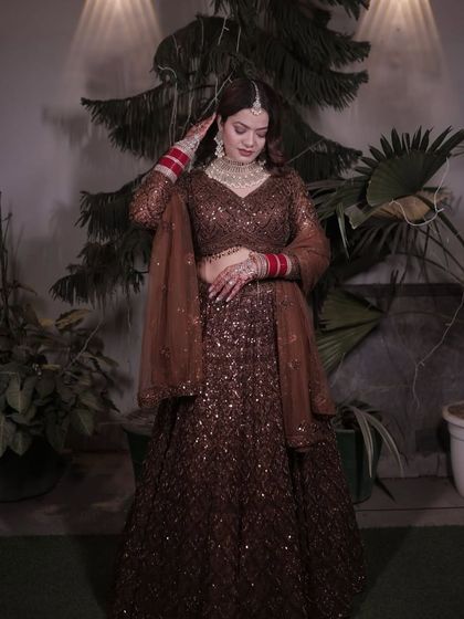 A unique choice for a modern bride. This deep brown lehenga is covered in sparkling sequins, offering a glamorous and unconventional look for a reception or sangeet night.